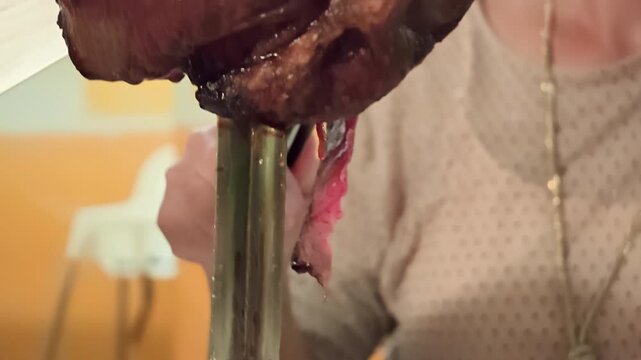 Close-up of freshly sliced picanha roast beef served on traditional skewer in a Brazilian churrascaria, showcasing grilled meat prepared in traditional Brazilian barbecue style. Elegant luxury dining