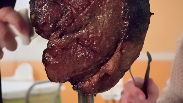 Juicy grilled picanha roast beef resting on a traditional skewer while being carved by chef, serving delicious meal experience at an authentic Brazilian churrascaria restaurant. Luxury romantic dinner