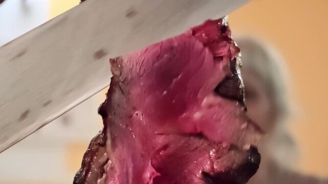 Chef's knife carving a tender, medium-rare picanha roast beef from a skewer, showcasing the succulent texture and juicy redness of the grilled meat at a traditional Brazilian steakhouse. luxury dining