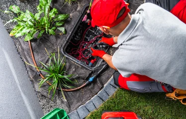 Technician servicing a garden irrigation valve box © Tomasz Zajda
