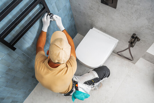 Worker adjusting the control on a bathroom towel radiator