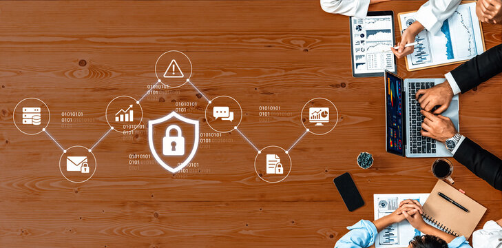 A top-down view of a collaborative workspace showcasing business professionals analyzing data and discussing digital security strategies on a wooden table with various graph visualizations. Nascent