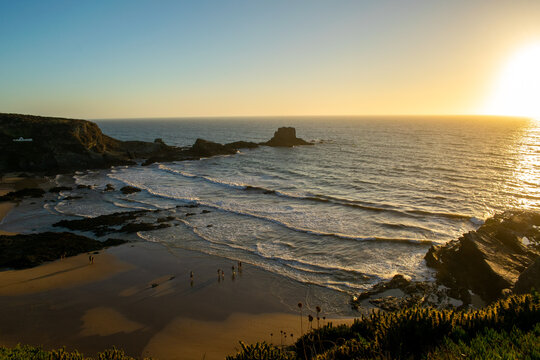 Golden Hour Coastal Sunset with Waves and Rocky Shore