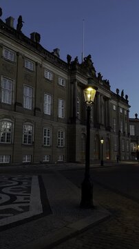 Copenhagen, Denmark -1.09.2026: View of the Amalienborg Square with a female royal guard, Royal Life Guard, standing in front of the Levetzau's Palace. Traditional Danish architecture. Royal residence