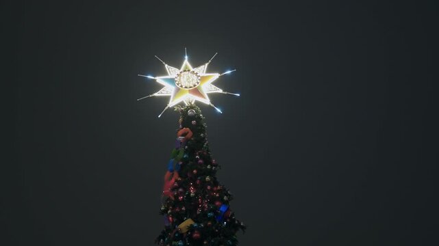 Illuminated Christmas Tree with Star Topper in Warsaw at Night
