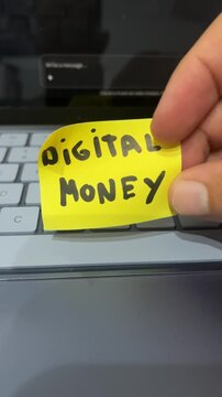 Hand holding digital money sticky note over laptop keyboard