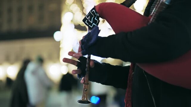 Street Performer Playing Bagpipes at Night in Warsaw, Poland