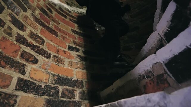 Explorer in Robust Boots Ascending Ancient Gdansk Basilica Stairs