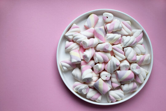 Multicolored marshmallows on a plate. Background or texture of blue and pink marshmallows.