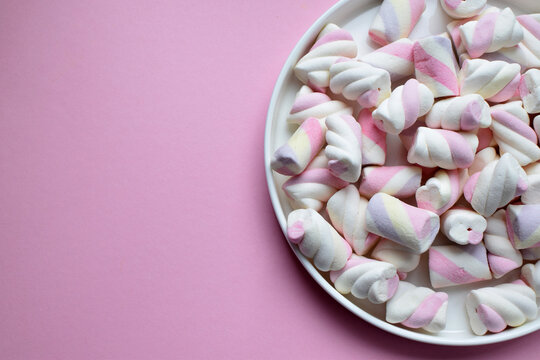 Multicolored marshmallows on a plate. Background or texture of blue and pink marshmallows. Copy space.