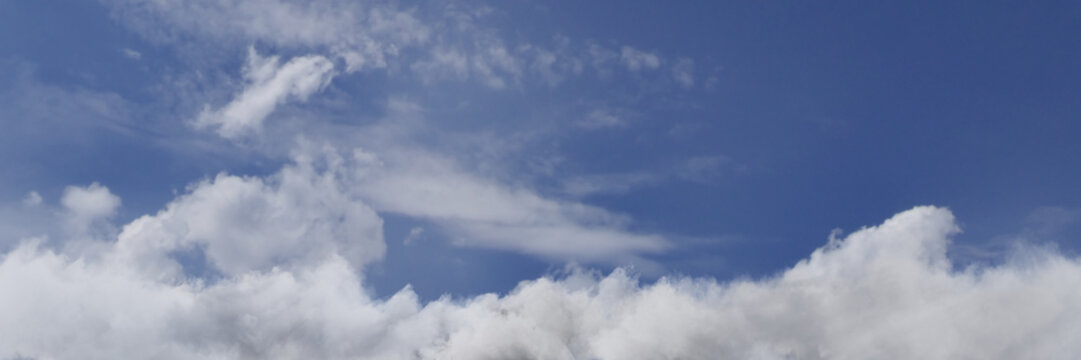 3D Rendering of a panoramic view to blue sky covered by fluffy white clouds.