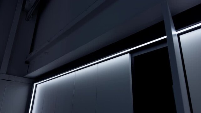 Minimal modern interior with glowing LED light strips along geometric wall panels and ceiling