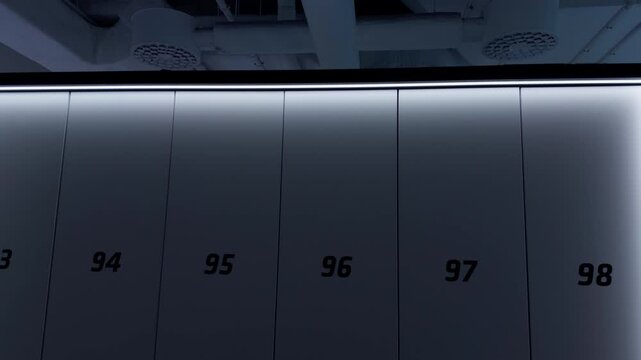 Numbered dark wall panels with glowing frame in modern interior under industrial ceiling
