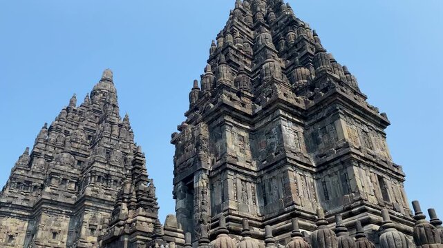 View of stone spire top architecture at Prambanan temple against clear blue sky, Yogyakarta, Central Java, Indonesia.