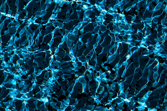 A close-up view of the detailed texture of the water in a pool or fountain, illuminated by the sun's rays