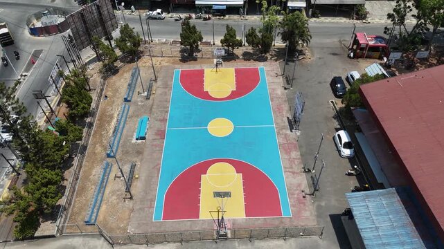 High angle view of a colorful sports court in an urban area with traffic on the adjacent street