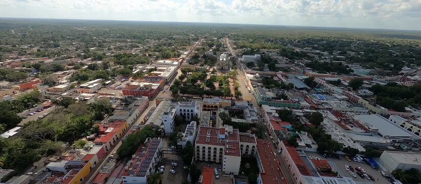 FPV drone flight over colonial city center, tropical architecture and historic plaza, aerial view of colorful buildings, streets and local culture, cinematic footage of authentic Mexican heritage 