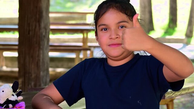 Latina girl making a like gesture with her hands.