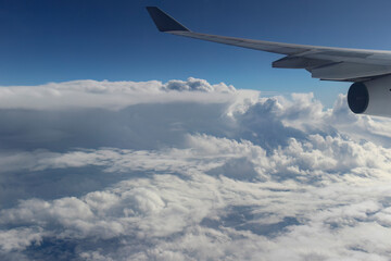 Obraz premium Aerial view from an airplane window showing the aircraft wing and engine flying above a sea of thick white clouds