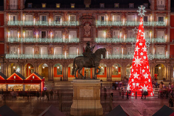 Stunning Christmas night at Plaza Mayor in Madrid featuring the illuminated red Christmas tree and Philip III statue ©  Josue Friedrich K.