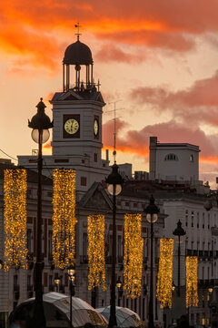 Beautiful sunset over the Real Casa de Correos at Puerta del Sol in Madrid with Christmas lights. Spain
