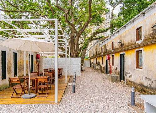 Old military barracks with yellow walls and patio.