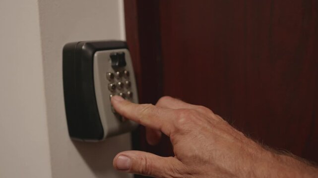 Hand interacts with electronic keypad lock, inserting key and pressing buttons to unlock door in a secure indoor environment