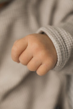 Closeup of a newborn infant baby hand in an outfit