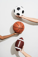 Fototapeta premium Hands holding various sports balls