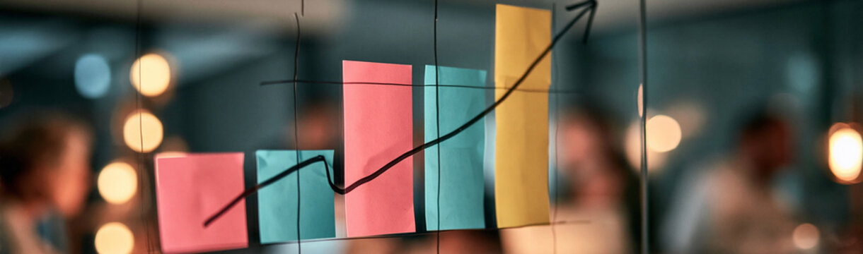 Business Growth Chart: A vibrant bar chart with an upward trending line, adorned with sticky notes, illustrates business growth and progress, hinting at successful strategy implementation.
