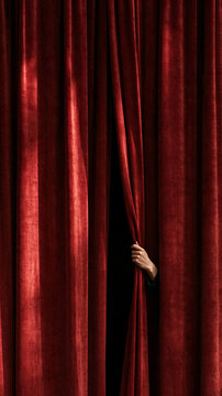 A Hand Pulls Back the Velvet Curtain: A single hand reaches through the rich folds of a deep red velvet stage curtain, hinting at a hidden scene or performance yet to be revealed.