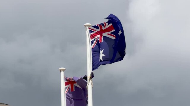 Australian and New Zealand Flags Waving Against Cloudy Sky