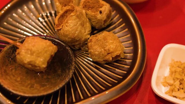 Dipping Fried Meatballs into Sweet Chili Sauce in Bangkok