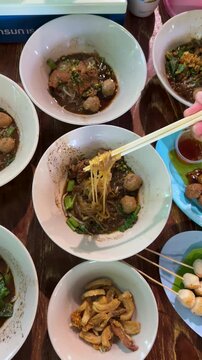 Eating Traditional Thai Boat Noodles With Chopsticks