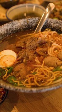 Bowl of Traditional Burmese Beef Noodle Soup on Restaurant Table