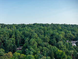 Fototapeta premium Aerial drone view of public school campus, playing fields, and mature trees in Bayberry Park, New Rochelle, New York