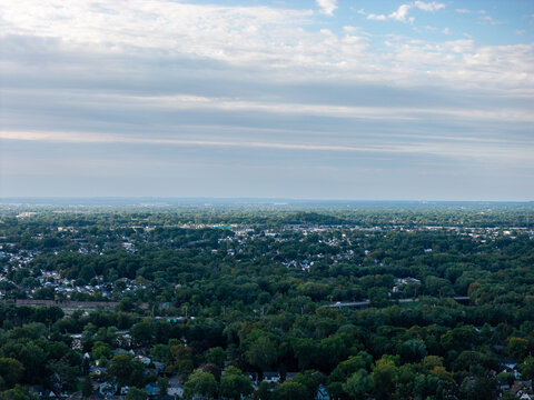 Panoramic view showing a wide urban cityscape, layered architecture, streets, rooftops and skyline beneath daylight clouds in a detailed high-angle travel composition with clear visual depth acros