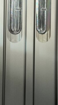Detailed view of metallic door jamb profile featuring lock strike plate cutouts