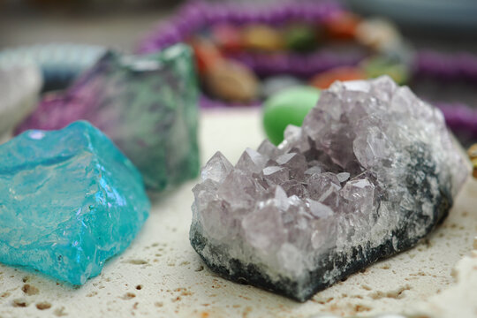 Colorful crystals displayed on a surface with beads in the background