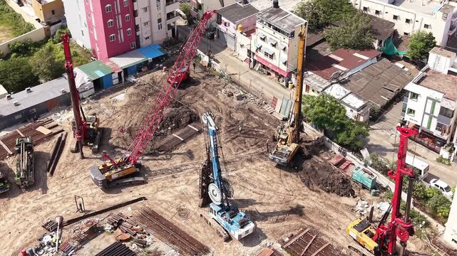 Red piling rig and construction machinery at urban building site real estate development