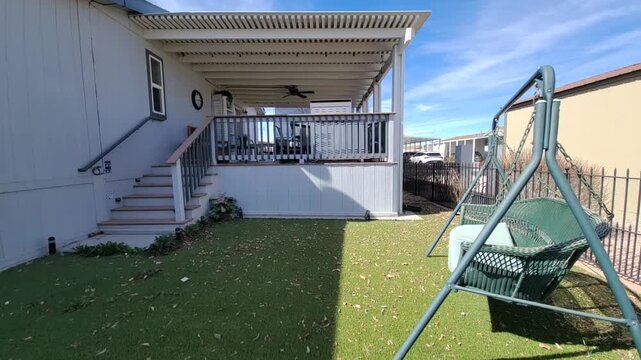 Elevated deck with car beside gray suburban house