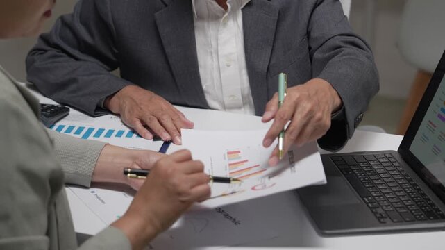 Close Up of Business Colleagues Analyzing Sales Reports and Charts in Office