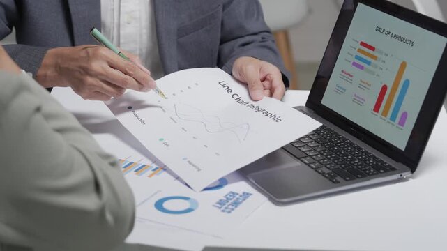 Close Up of Business Colleagues Analyzing Sales Reports and Charts in Office