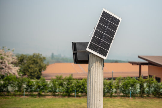 Pole with solar-powered light and solar panel in rural countryside, sustainable and ecological green energy, pillar in farm village with mounted solar technology setting for renewable energy from sun.
