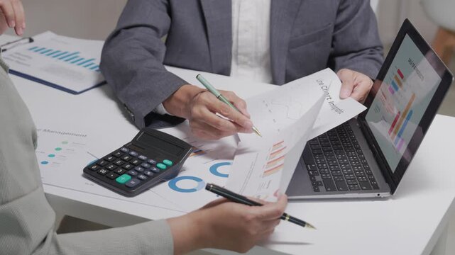 Close Up of Business Colleagues Analyzing Sales Reports and Charts in Office