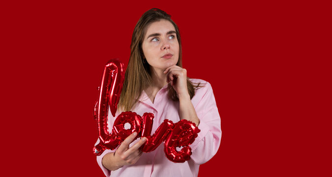 Woman with love sign thinking against red background. Copy space banner 