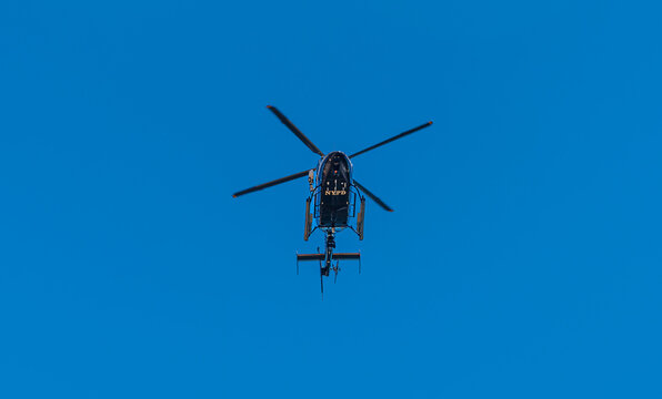 New York, New York, USA, June 15, 2026: A New York City Police Department (NYPD) Aviation Unit helicopter in flight against a clear blue sky.