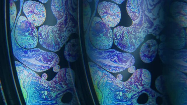 Flow emulsion. Psychedelic abstraction. Blur blue purple green color round gasoline texture chemical liquid leak on dark black background.