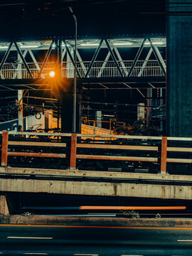 Concrete Overpass Pillar and Guardrail Beneath Elevated Train Station at Night