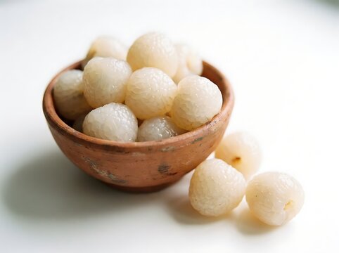 A delightful close up showcases a rustic earthenware bowl brimming with soft pale spherical indian sweets likely 'rasgulla' presented on a clean